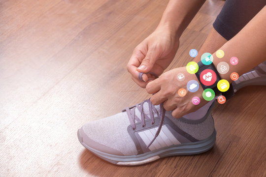 hand tying shoelaces wearing watchband touchscreen smartwatch with application icons