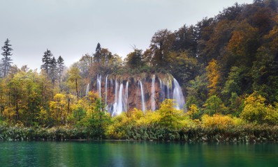 Croatia. Plitvice Lakes. Panorama waterfall in rainy weather wit autumn trees and gray skies