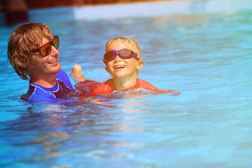 Father teaching his little son to swim