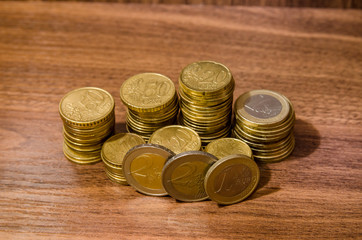 different  golden euro coins on wooden table background