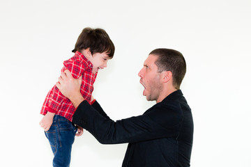 portrait of angry father scolding his son holding his arms, isolated on white background