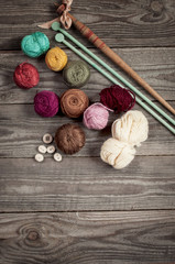 retro wooden spindle and purple knitted socks with  a ball of yarn