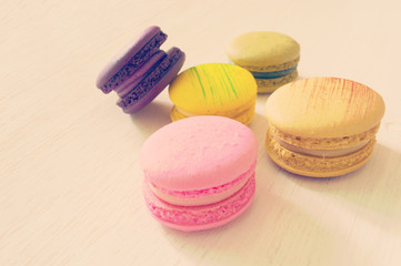 colorful macarons lay on wooden bacground
