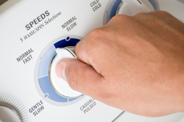 Washing Machine Dial Turned by Male Hand
