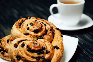 Tea and homemade bakery with chocolate on dark wooden table.