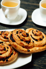 Tasty pretzels and two cups of tea on dark wooden table
