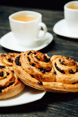 Tasty pretzels and two cups of tea on dark wooden table