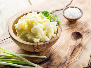 Mashed potatoes in the wooden bowl on the service tray.