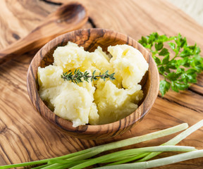 Mashed potatoes in the wooden bowl on the service tray.