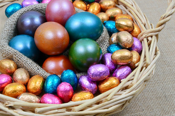 Colorful egg and chocolate for Easter in basket
