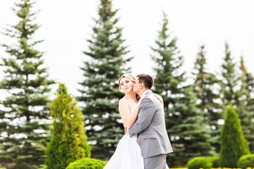 Fototapeta na wymiar Groom kissing bride on their wedding day
