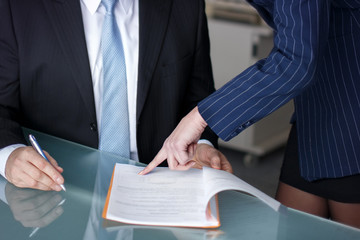 Businesswoman pointing to signature place for boss