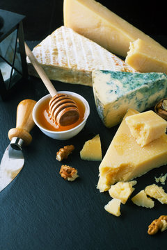 Delicious cheeses on a board with honey, nuts and wine