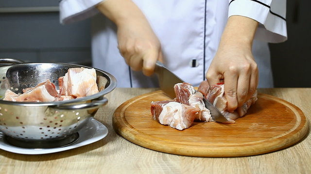 a cook cuts the raw meat, pork ribs