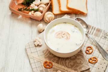
mushroom soup with potatoes , carrots , green and white toast on a wooden background