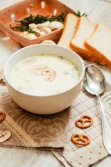 
mushroom soup with potatoes , carrots , green and white toast on a wooden background