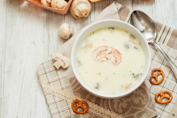 
mushroom soup with potatoes , carrots , green and white toast on a wooden background