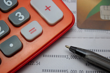 A pen ,calculator, credit card on account book. selective focus.