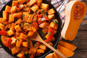 Pumpkin curry with herbs on a plate close-up. Horizontal top view
