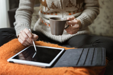 Fototapeta na wymiar Woman Using Digital Tablet And Drinking Coffee At Home 