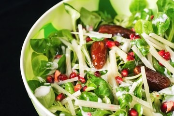 Lettuce salad with dates, pomegranate grains and cheese
