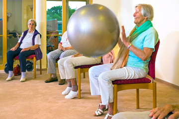 Elderly ladies working out with a pilates ball.