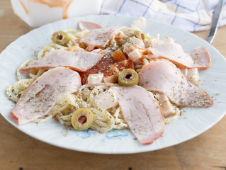 Close up of spiced pasta with ham ketchup and olives