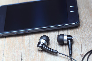 Earphones on phone or tablet close up