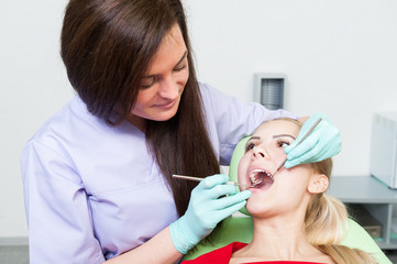 Friendly dentist woman examining beautiful teeth