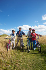 Grandparents With Children Cycling Through Countryside