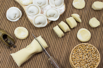 Dumplings on the board, cutting the dough into pieces, the knife