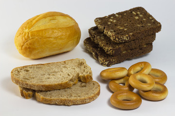 Sliced black and white bread, bun and bagel on a white backgroun