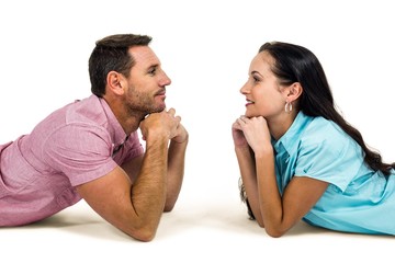 Happy couple laying on floor looking at each other