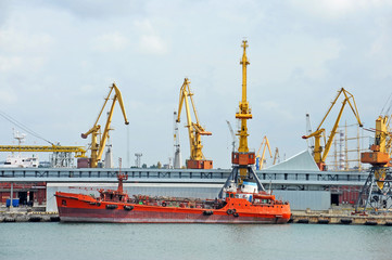 Fototapeta premium Bunker ship (fuel replenishment tanker) under port crane