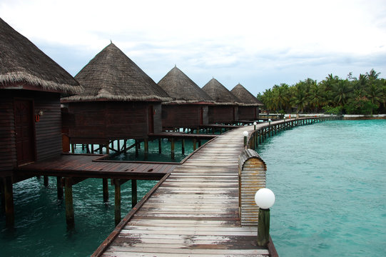 Bungalow and timber pier at island resort Maldives