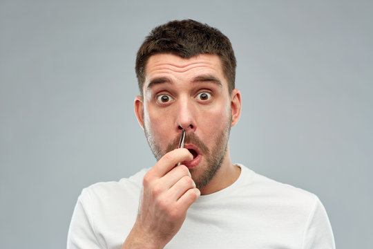 Man With Tweezers Tweezing Hair From Nose