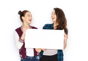 smiling teenage girls holding white blank board