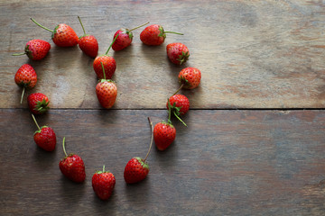 strawberry in heart shape on the wood table