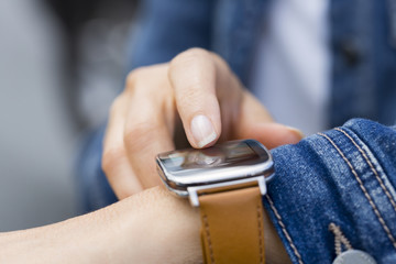 Closeup of woman's hands touching the  screen of her swmartwatch