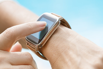 By the pool a woman using her smartwatch