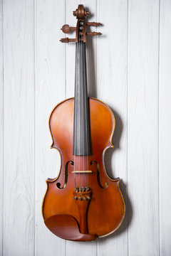 Old violin on wooden background.