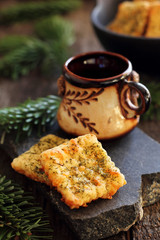 two homemade cheese crackers and a cup on a stone