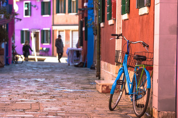 Fototapeta na wymiar Destroyed sometimes bicycle leaning colored house in Burano, Ita
