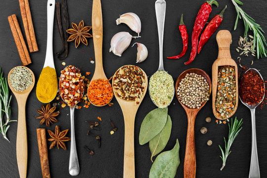Fragrant seasonings and spices on black background.