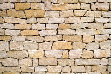 a textured yellow limestone brick wall 