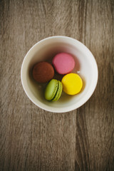 Macaroons on the wooden table with golden ribbon.