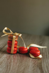 Macaroons on the wooden table with golden ribbon.