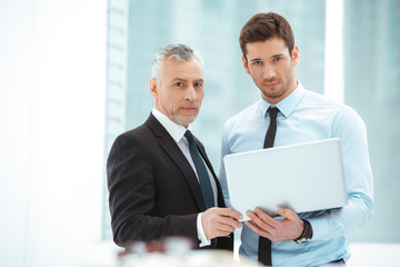 Aged and young businessmen having meeting