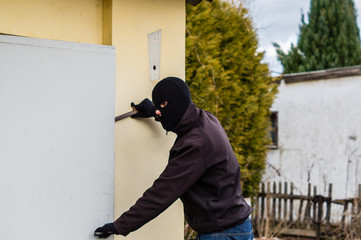 Mann öffnet Haustür mit Brechstange