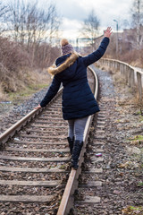 Frau balanciert auf Schiene